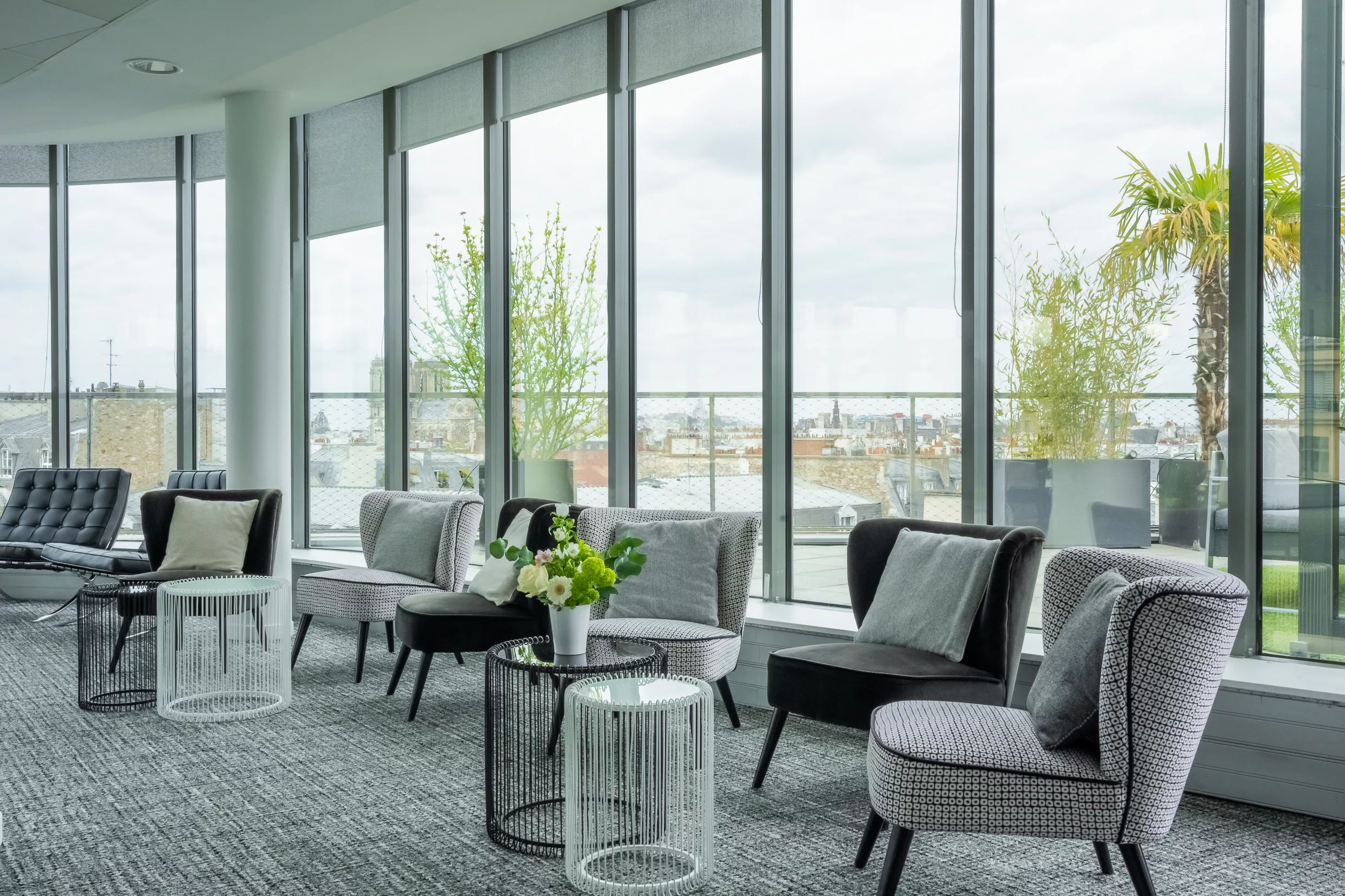 Le Sky Lounge : fauteuils face aux baies vitrées donnant sur les toits de Paris