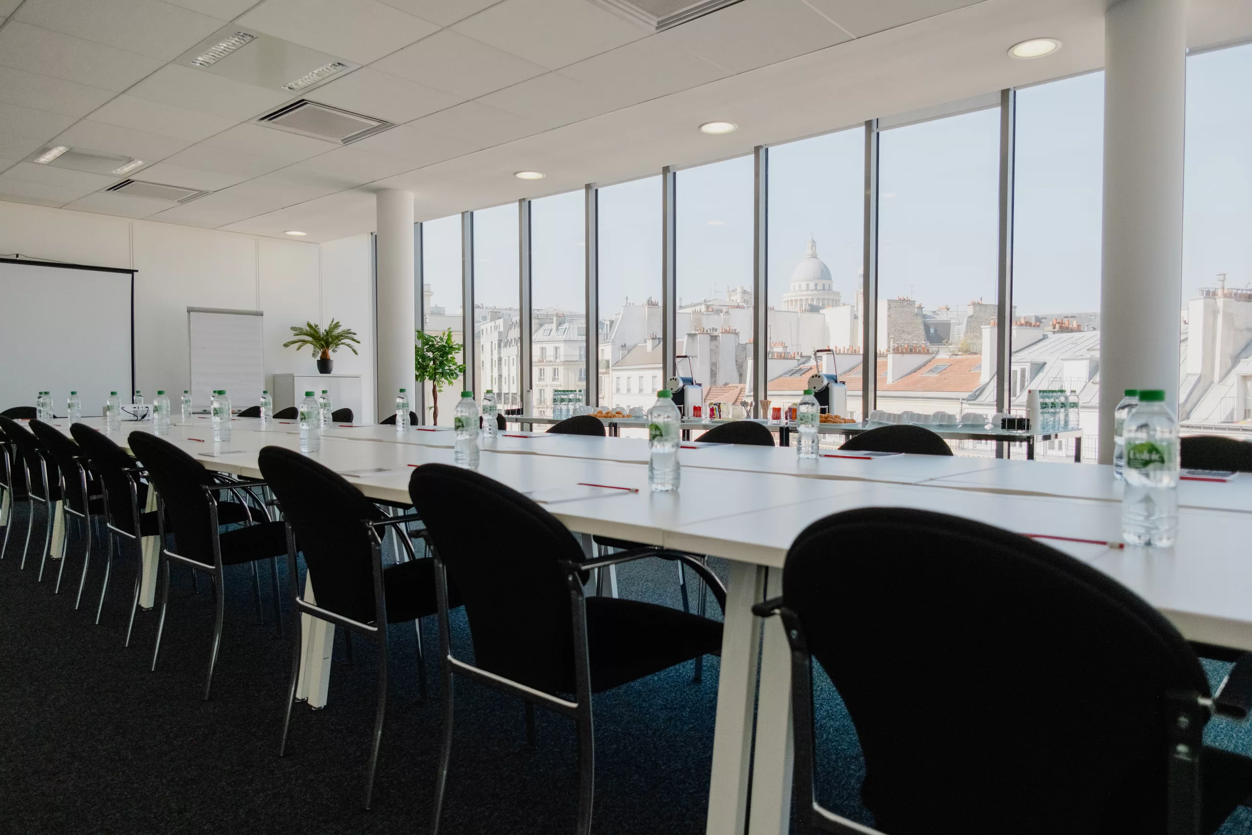 Salle aménagée en board autour d’une grande table de réunion