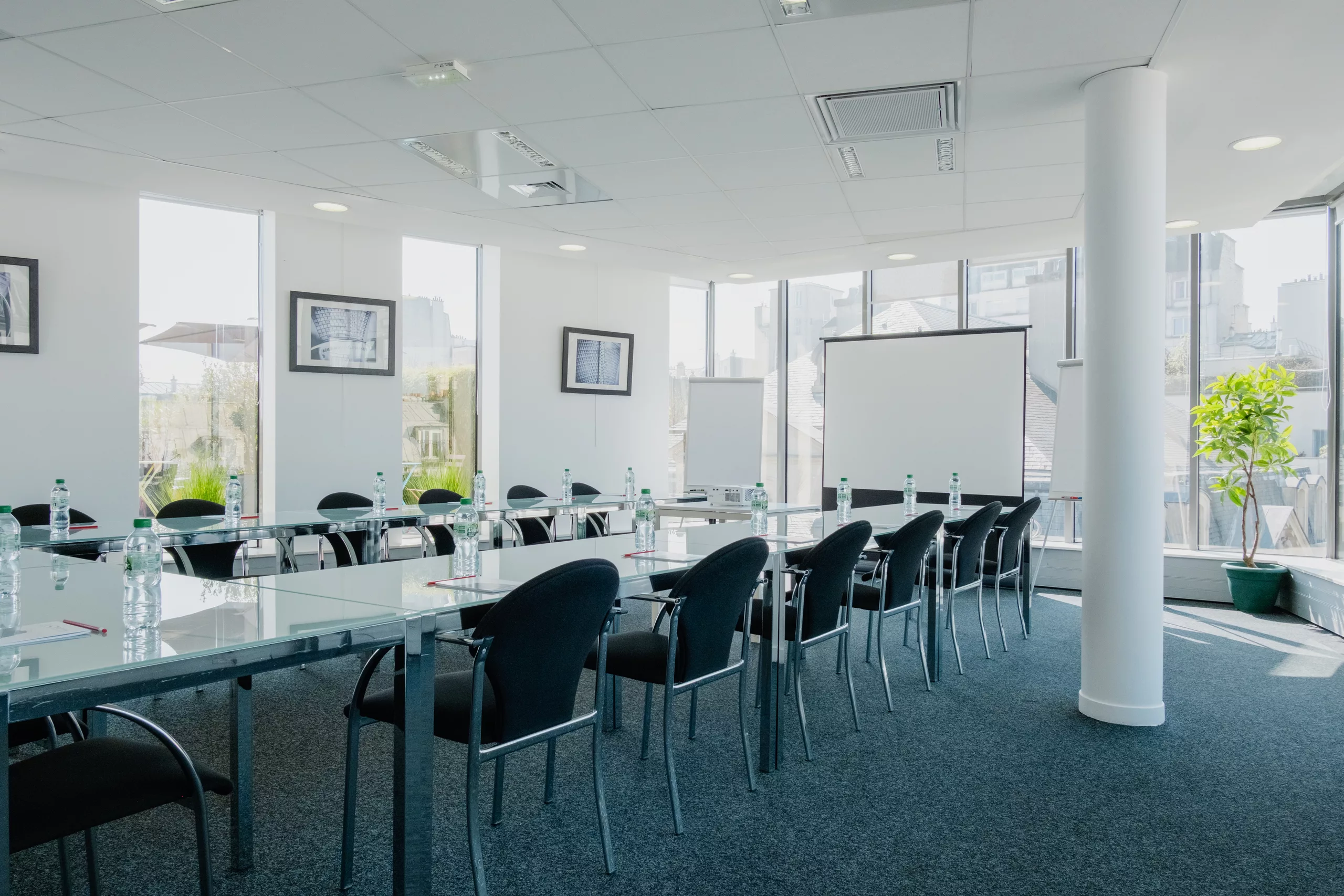 Salle de réunion en disposition en U, avec écran de projection