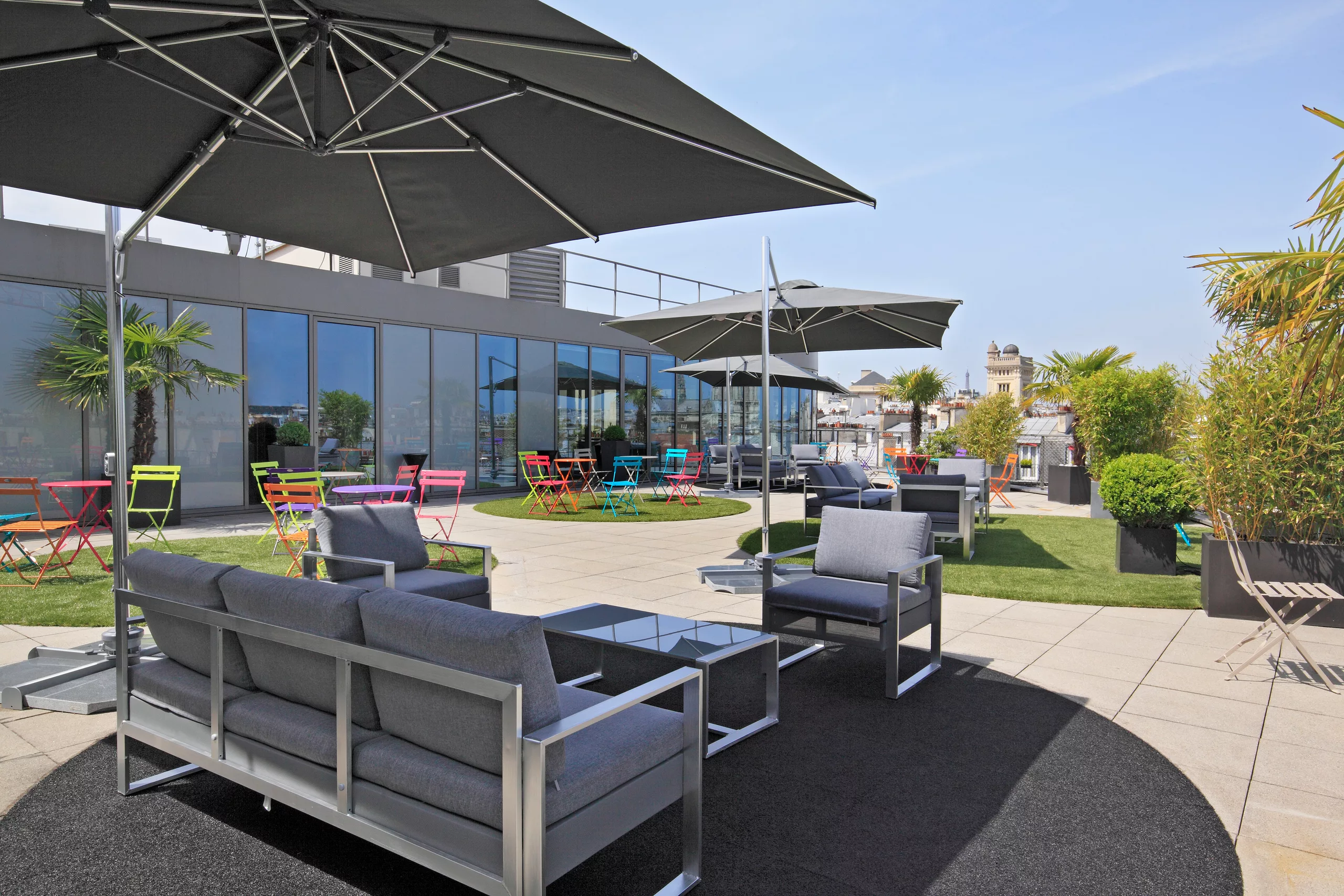 Salon d’extérieur sous un grand parasol, sur le rooftop